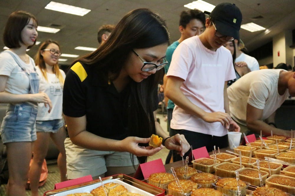 Katarina, a junior at ASU and President of the Philippine American Student Association, tries a variety of moon cakes at the Mid-Autumn Festival on Sept. 13, 2016.
