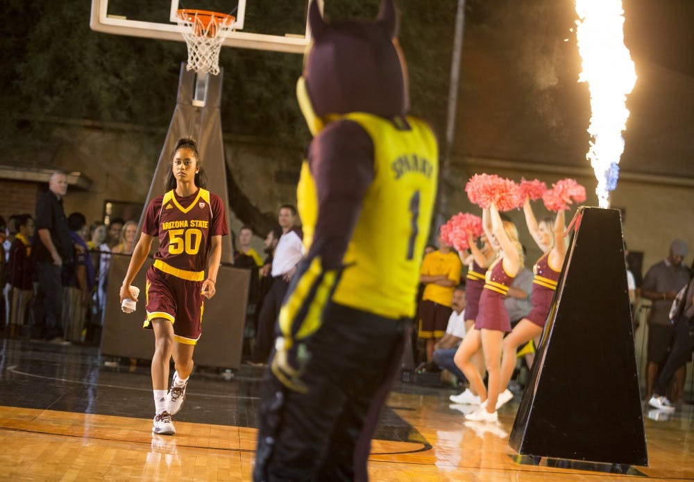 Sophomore guard Armani Hawkins, left, is greeted by mascot Sparky, center, as she enters the court during player introductions before the start of Mill Madness on Friday, Oct. 14, 2016.