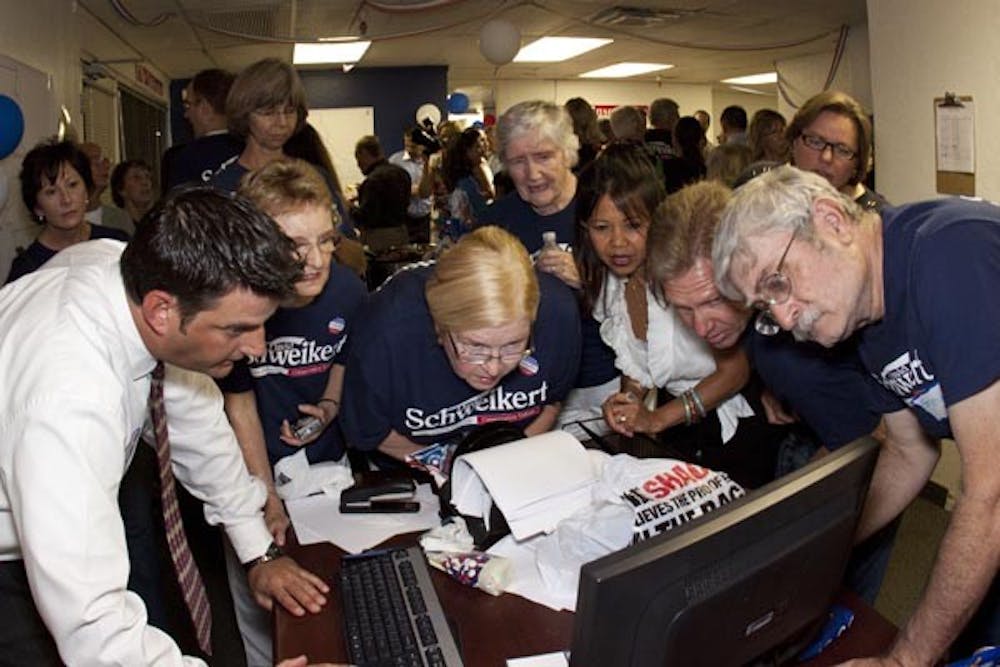 AWAITING A WIN: Campaign members for David Schweikert anxiously crowd around the computer monitor as election poll results filter in Tuesday night. (Photo by Annie Wechter)