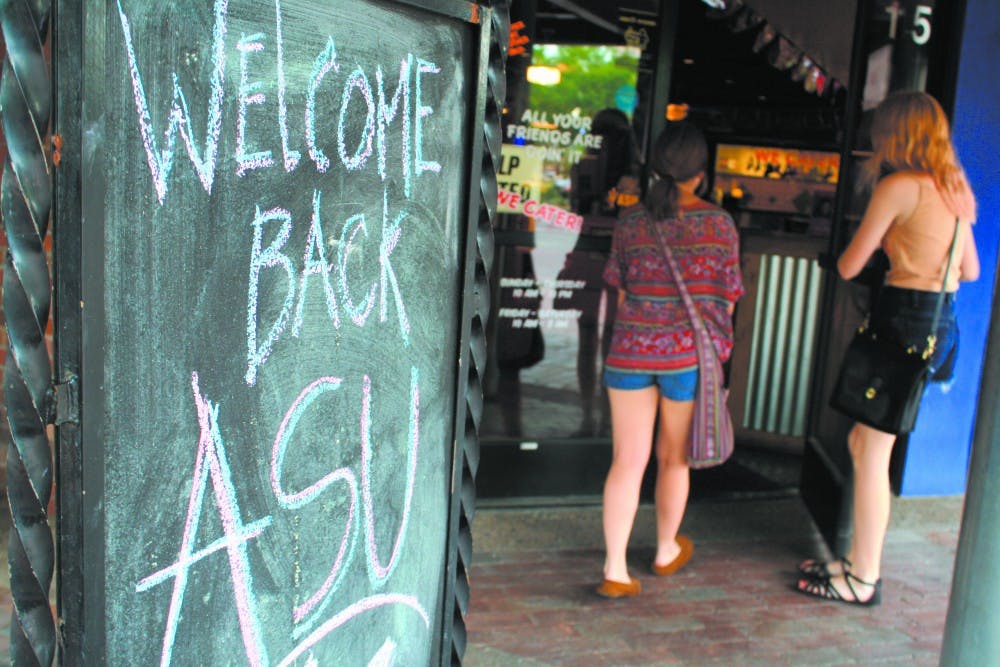 Two customers enter Fuzzy’s Taco Shop on Mill Avenue Wednesday. Local businesses surrounding the Tempe campus offer student deals in the beginning of the fall semester.  (Photo by Jessie Wardarski)