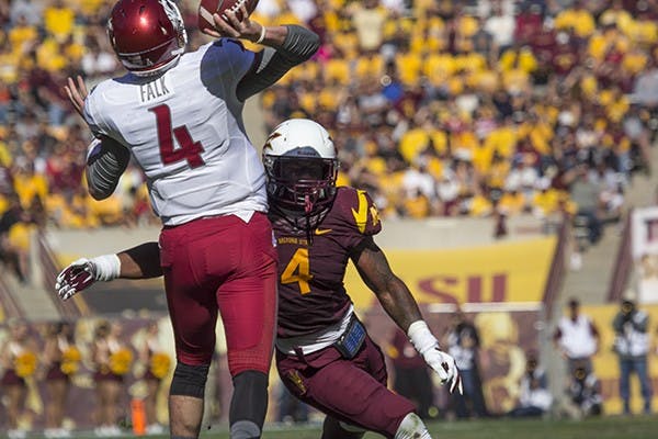 Then-redshirt freshman quarterback Luke Falk throws a pass as freshman linebacker&nbsp;DJ Calhoun&nbsp;brings pressure.