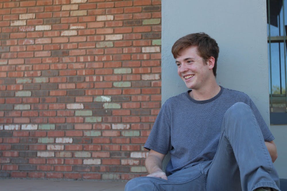 Robbie Pfeffer sits on a stoop on 5th Street, what he calls a representative epicenter of local music in downtown Phoenix. Pfeffer has started his own record label, wher ehe plans to sign on bands locally as well as nationally. (Photo by Dominic Valente)