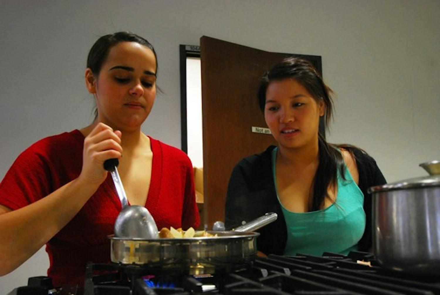 Nutrition majors Shannon Trun and Bettina Mielle prepare a sweet and sour pork stew for their class on the Downtown campus. (Photo by Murphy Bannerman)