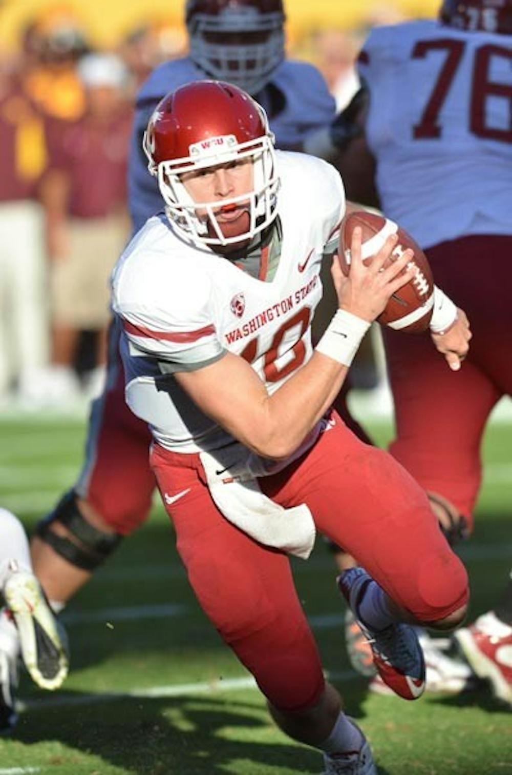 NOWHERE TO RUN: Washington State sophomore quarterback Jeff Tuel scrambles out of the pocket against ASU on Saturday. The Cougars failed to score any points for the first time this season. (Photo by Aaron Lavinsky)