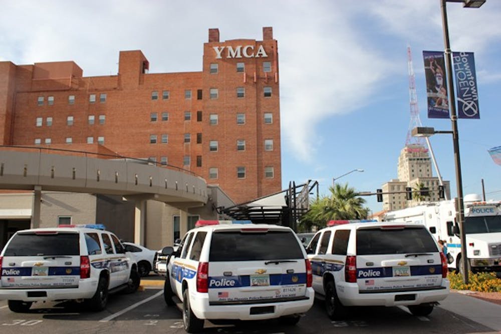 Police gather outside of the YMCA in downtown Phoenix after a Phoenix Police officer shot a man inside.  (Photo by Sam Valtierra Bush)