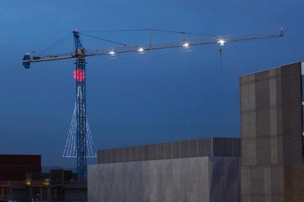 CHRISTMAS CRANE: A crane suspends a gigantic Christmas tree of lights, over an ASU construction sight between Rural Rd. and McCallister Ave. (Photo by Rosie Gochnour)