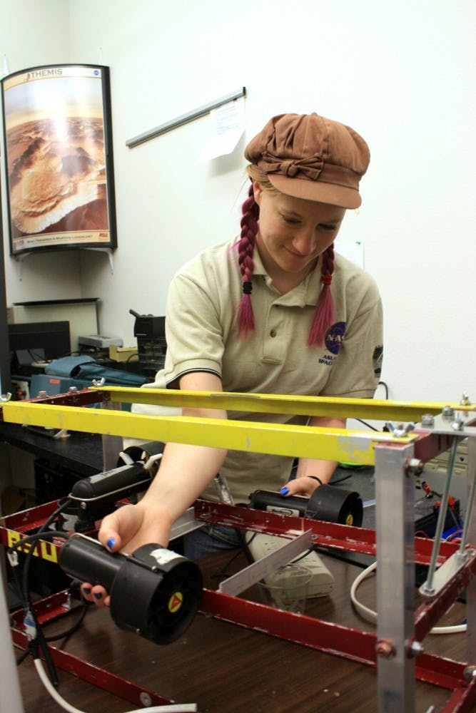 Emily McBryan demonstrates how the autonomous robot will function once it is placed on water.  Photo by Noemi Gonzalez.