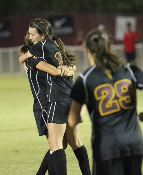 Freshman forward Cali Farquharson (center) embraces a teammate after her goal that put the up Sun Devils 2-1 to defeat UA on Friday. (Photo by Kyle Newman)