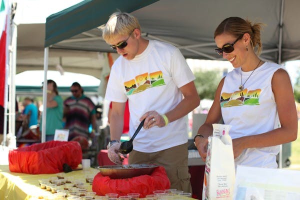 Non-profit graduate student Susan Moseley sets up salsa cups with her husband Mikael Moseley, a Business graduate student, who volunteered for his wife's organization salsa entry at the 2nd annual Salsa Challenge at Tempe Beach Park on Saturday. (Photo by Perla Farias)