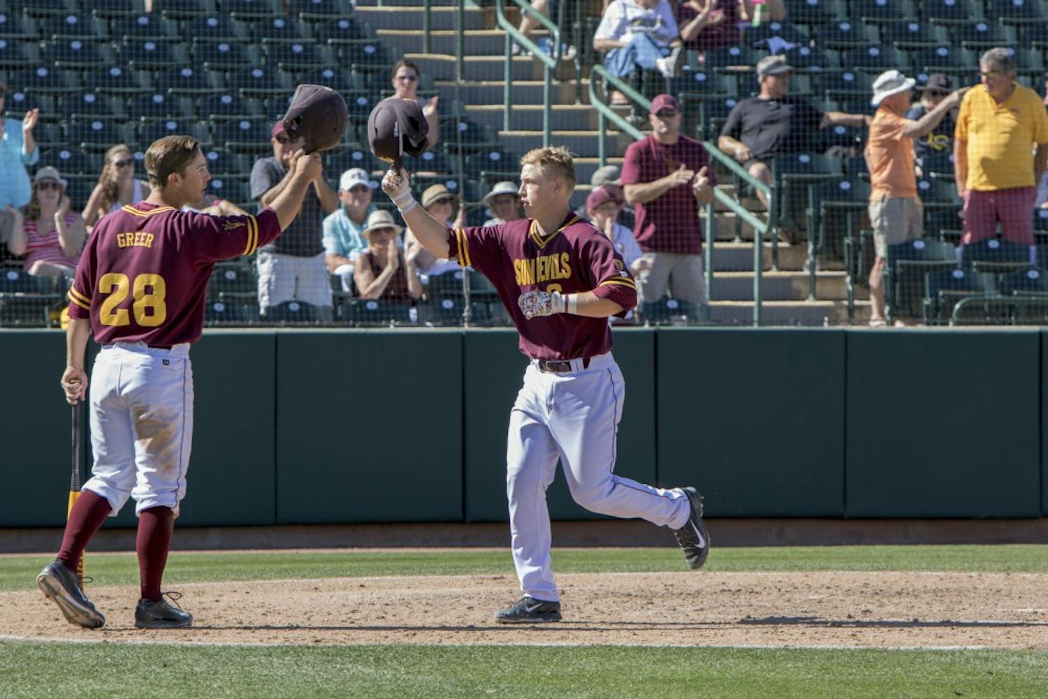 Sophomore Brian Serven (right) meets Sophomore David Greer (left) at home plate after hitting a home run against Long Beach State at Phoenix Municipal Stadium on Sunday March 08, 2015. The Sun Devils defeated the Dirtbags 9-3. (Jacob Stanek/The State Press)