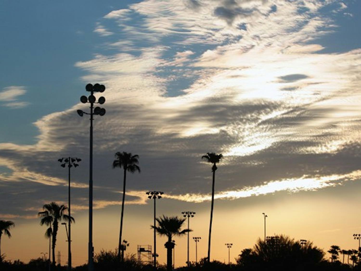 RISE N' SHINE: Palm trees outside of the Sun Angel Stadium are silhouetted as the sun rises over Arizona Sept. 7. (Photo by Beth Easterbrook)
