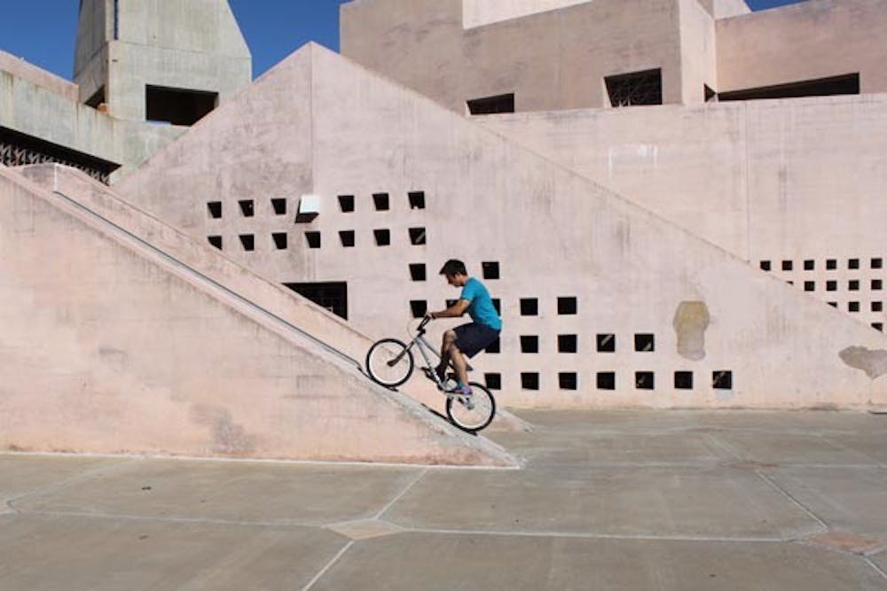 CLIMBING UP: Microbiology senior Alan Wrobleski, takes a break between classes to sharpen his bicycling skills outside the ASU Art Museum Tuesday afternoon. (Photo by Rosie Gochnour)