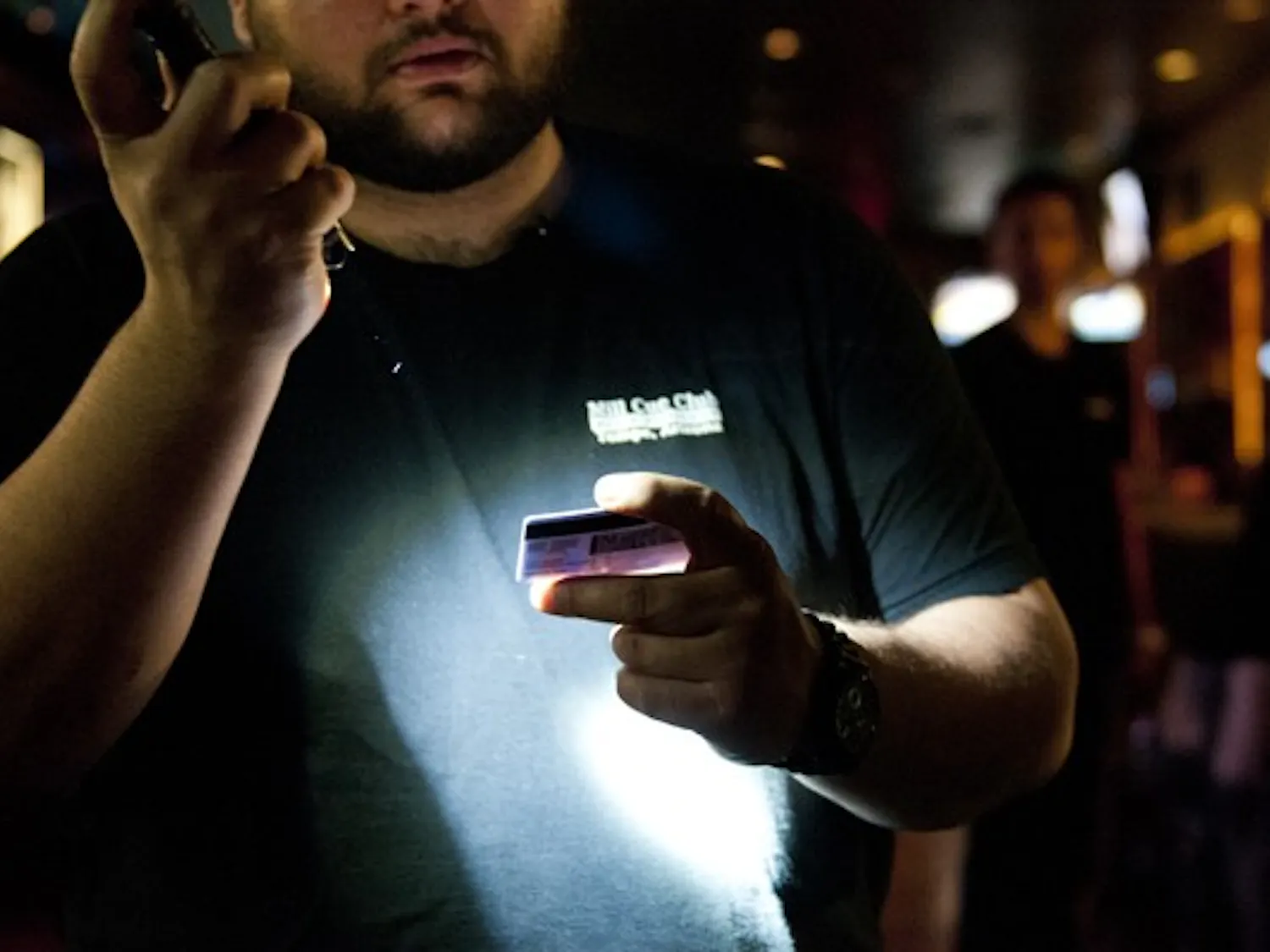 Security at Cue Club on Mill Avenue checks the authenticity of a driver’s license in Tempe, Arizona, on Friday, April 12, 2013.