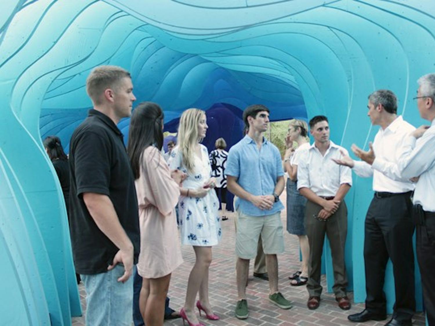FINISHED PRODUCT: The winners of the art contest are congratulated by the Director of The Design School Darren Petrucci, left, and the Dean and Director of the Herberger Institute of Design and the Arts Kwang-Wu Kim, right. The students spent nearly four months constructing the structure. (Photo by Beth Easterbrook)
