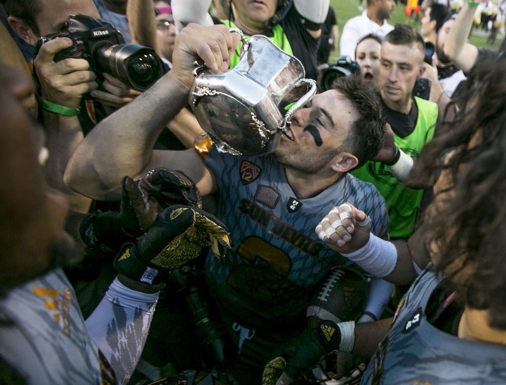 Redshirt senior quarter back Mike Bercovici kisses the Territorial Cup after winning a game against the Wildcats at Sun Devil Stadium in Tempe, Ariz., on Saturday, Nov. 21, 2015. The ASU Sun Devils took down the UA Wildcats, 52-36. 