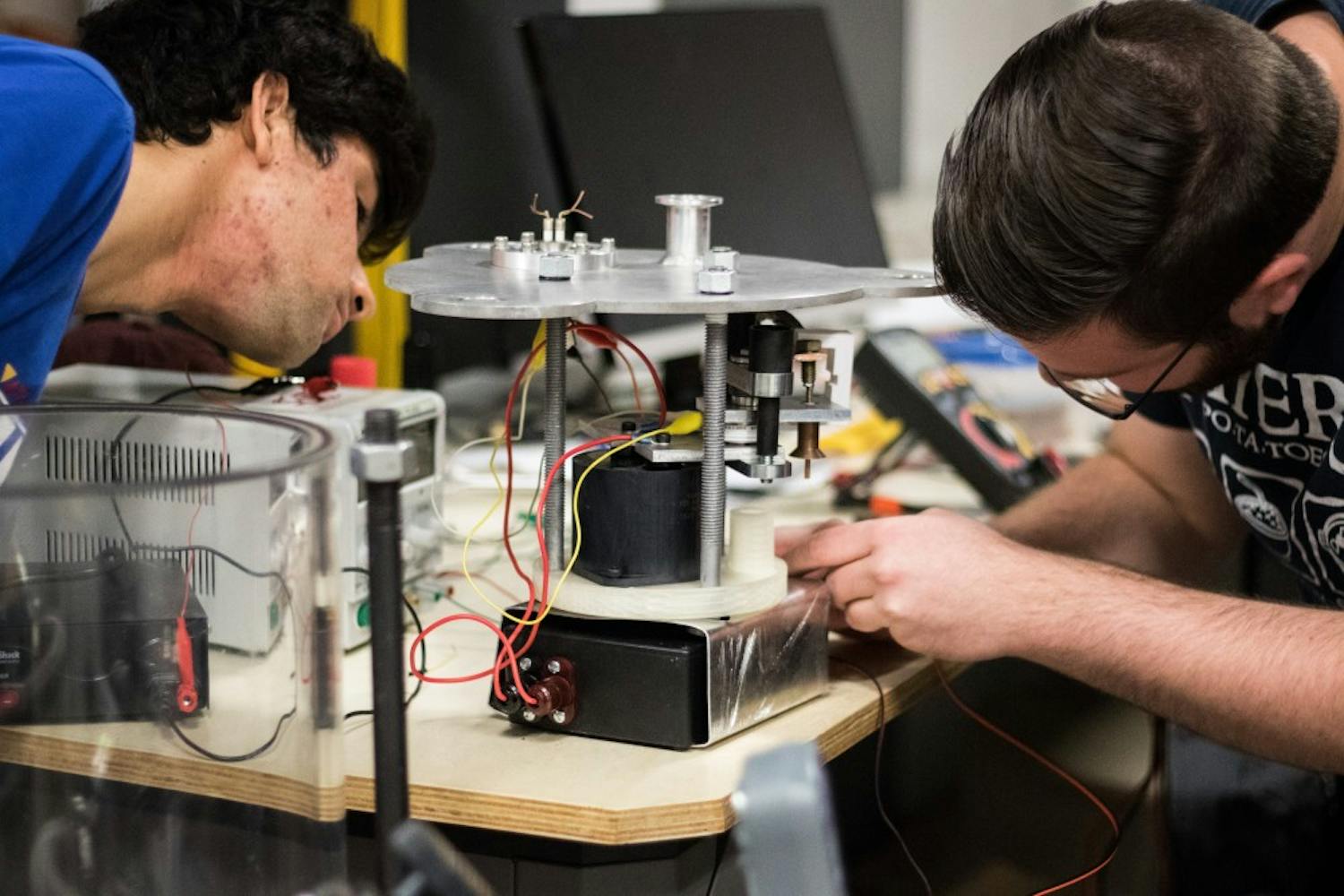 Aditya Van Der Khuller, left, and Joe Mayer adjust the spark mechanism on the pulse plasma thruster on Saturday, Feb. 18, 2017.