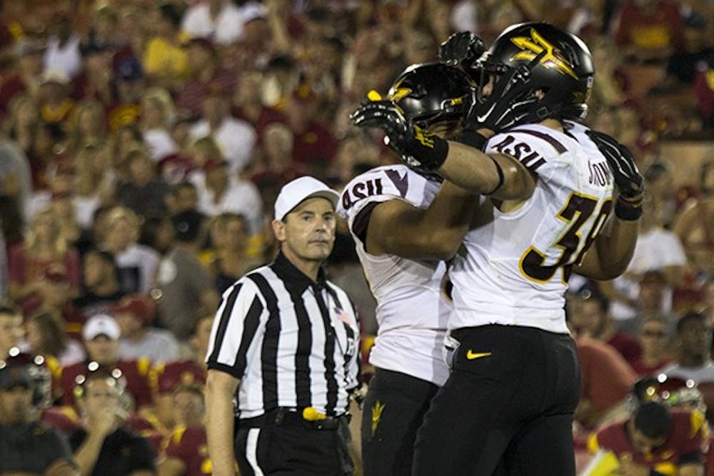 Redshirt junior defensive back Jordan Simone celebrates with his teammate during a game against USC on Oct. 4, 2014. ASU won against USC 38-34. (Photo by Alexis Macklin)