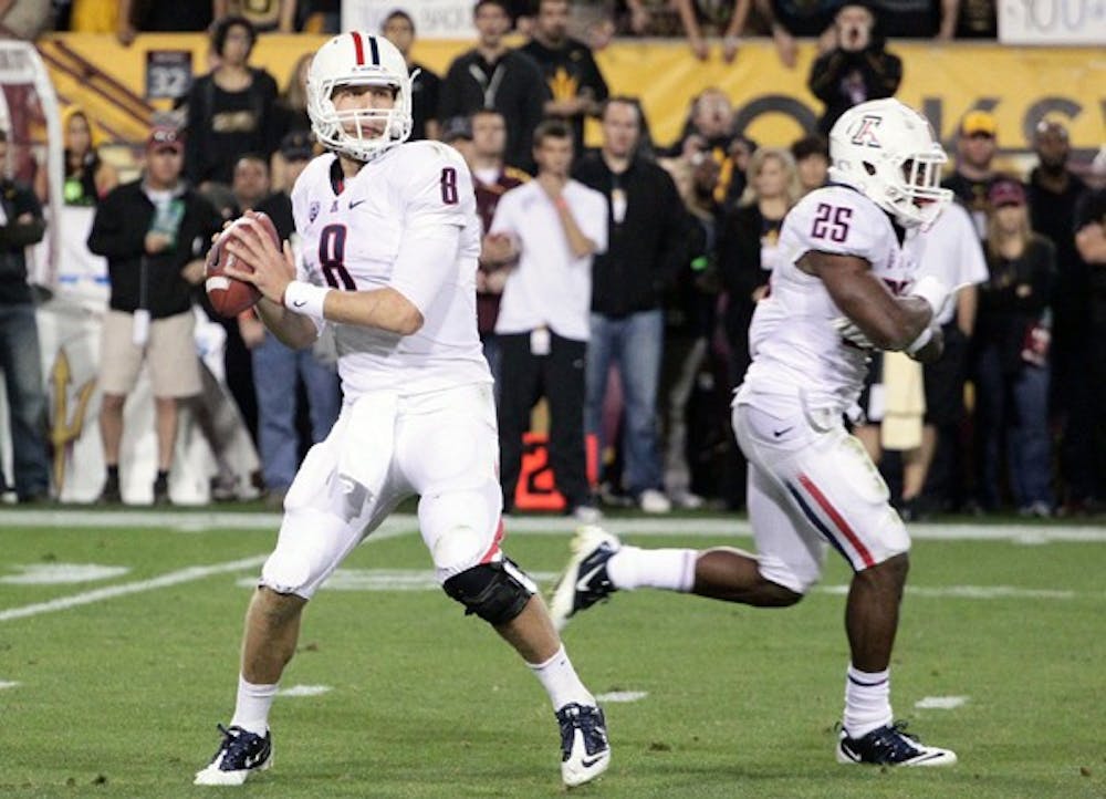 UA senior quarterback Nick Foles looks for a pass down the right sideline during the Wildcats’ 31-27 win over ASU on Saturday. Foles threw for 370 yards and two touchdowns in the victory, despite leaving injured in the fourth quarter. (Photo by Beth Easterbrook)