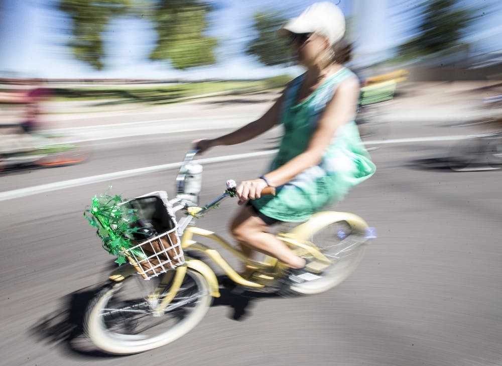 A biker rides past Tempe Beach Park during the bike parade on Saturday, Oct. 3, 2015. The annual Tour de Fat celebration features a costumed bike parade around Tempe.