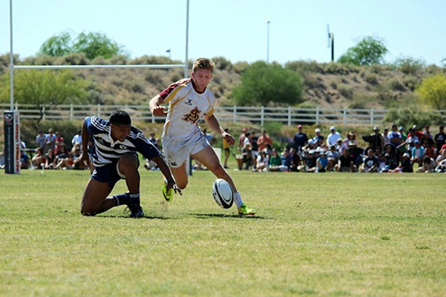 Senior center Adam Sandstrom punts the ball away from a BYU player in the Rugby Bowl in Scottsdale on April 12. ASU lost against BYU 52-26. (Photo by Alexis Macklin)