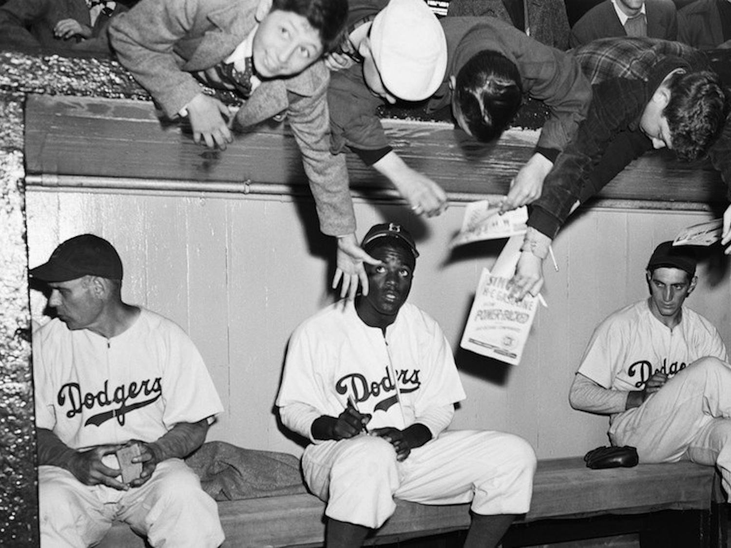 Eddie Dweck, the first child on the left, gets an item signed by Jackie Robinson prior to an exhibition game on April 11th, 1947. Robinson would break Major League Baseball’s color barrier four days later. Photo courtesy of Corbis Images 