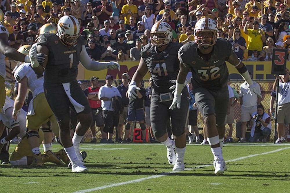 Senior defensive lineman Marcus Hardison, sophomore linebacker Viliami Latu and redshirt junior linebacker Antonio Longino celebrate after they stop Notre Dame's offensive run at a home game on Saturday, Nov. 8, 2014. ASU won against Notre Dame 55-31. (Photo by Alexis Macklin)