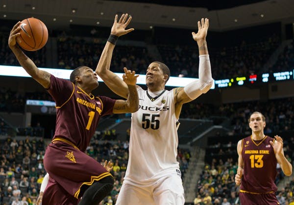 Freshman guard Jahii Carson drives to the basket under heavy pressure from Oregon center Tony Woods. The Oregon Ducks defeated the ASU Sun Devils 68-65 at Matt Knight Arena on January 13th, 2013. (Courtesy of Michael Arellano)