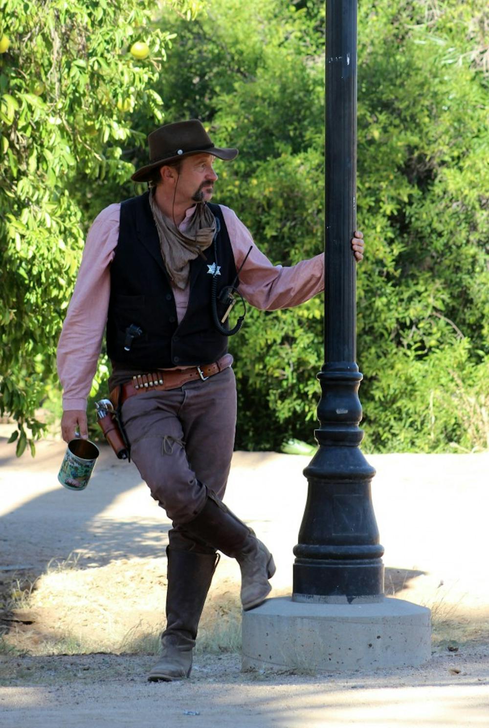 Tom B. Stone, a theatrical character and member of a variety act, sips on some sarsaparilla. 