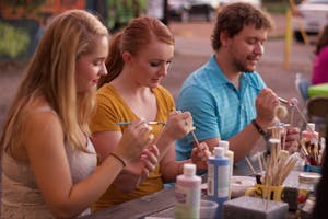 Emma Lunsford (left), Ashley Gilliam and Aaron Hintz volunteer to paint the beads that will eventually become bells during a grand opening celebration of the Phoenix location of the Ben's Bells Project on Friday, Sept. 18, 2015.