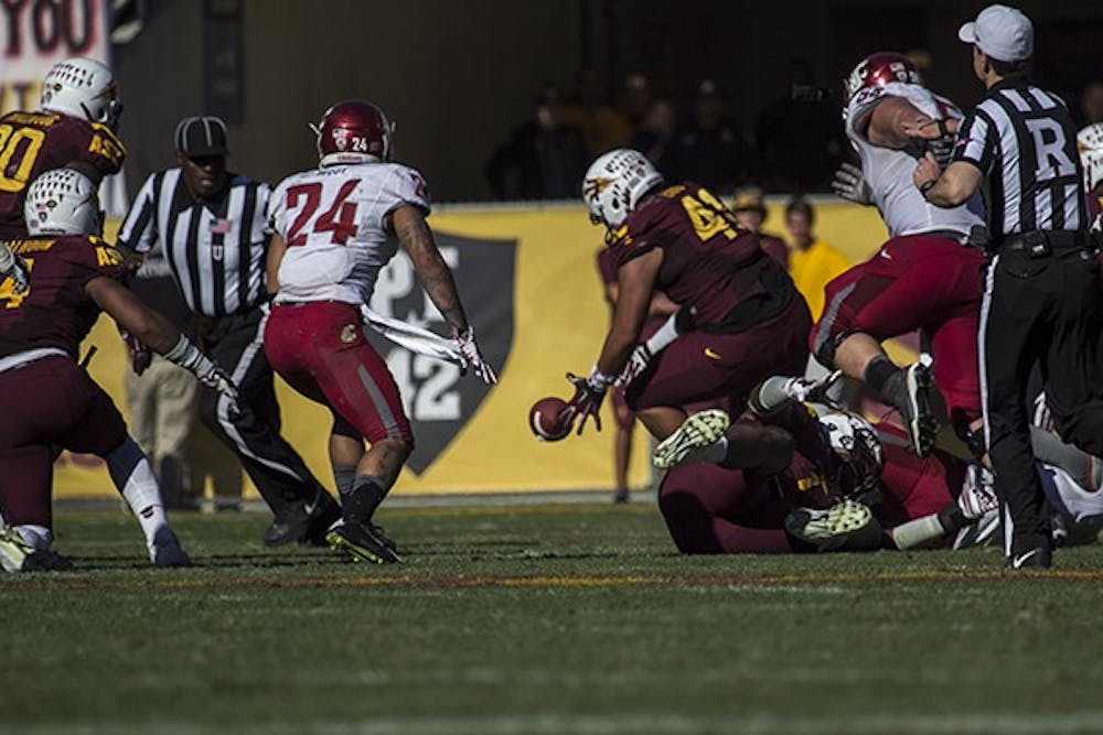 Redshirt junior defensive lineman Ami Latu scoops a fumble from WSU quarterback Luke Falk in the 4th quarter. (Photo by Alexis Macklin)