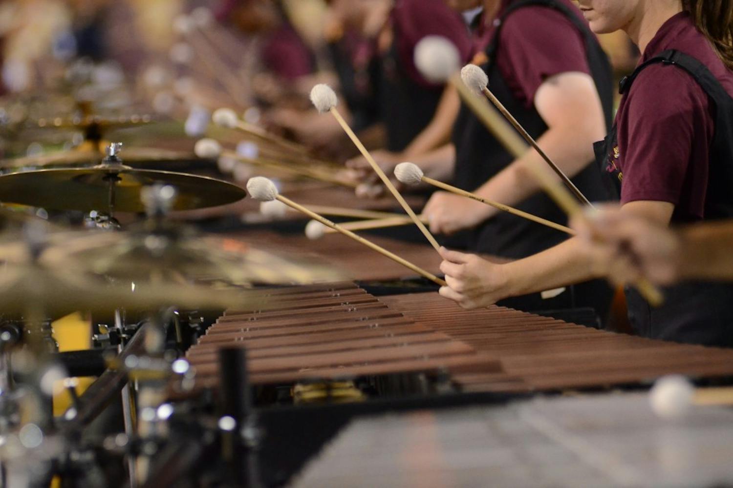 Percussionists in the ASU marching band play a number as they practice before a football game in Tempe. The band consists of percussionists, horn players, dancer as well as a full drum line. (Photo by State Press Staff)