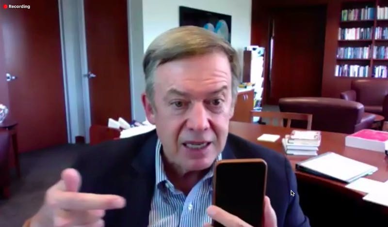 President Michael Crow motioning towards his phone as he talks about the new COVID testing plan at an ASU student forum over Zoom on Thursday, Sept. 3, 2020.