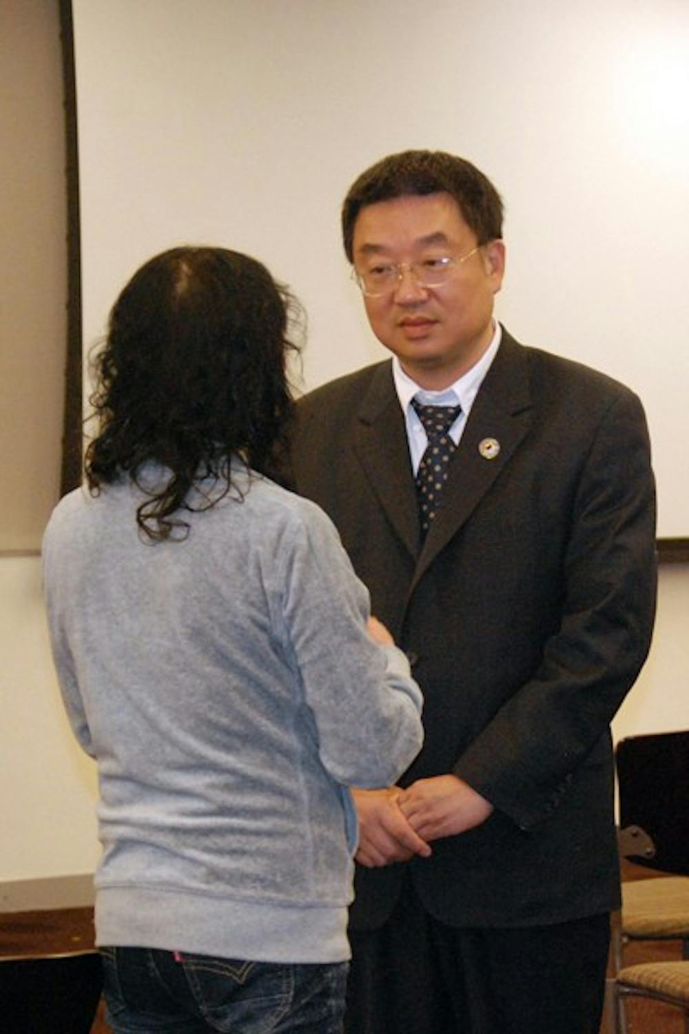 DEFENDING RIGHTS: Shinzhong Chen speaks with Liu Ai Ying, a Chinese immigrant who moved from China three months ago to escape from Chinese persecution of Fulan Dong. Chen spoke to students and faculty in the Memorial Union Monday evening about the Chinese government's violations of human rights. (Photo by Julie Vitkovskaya)