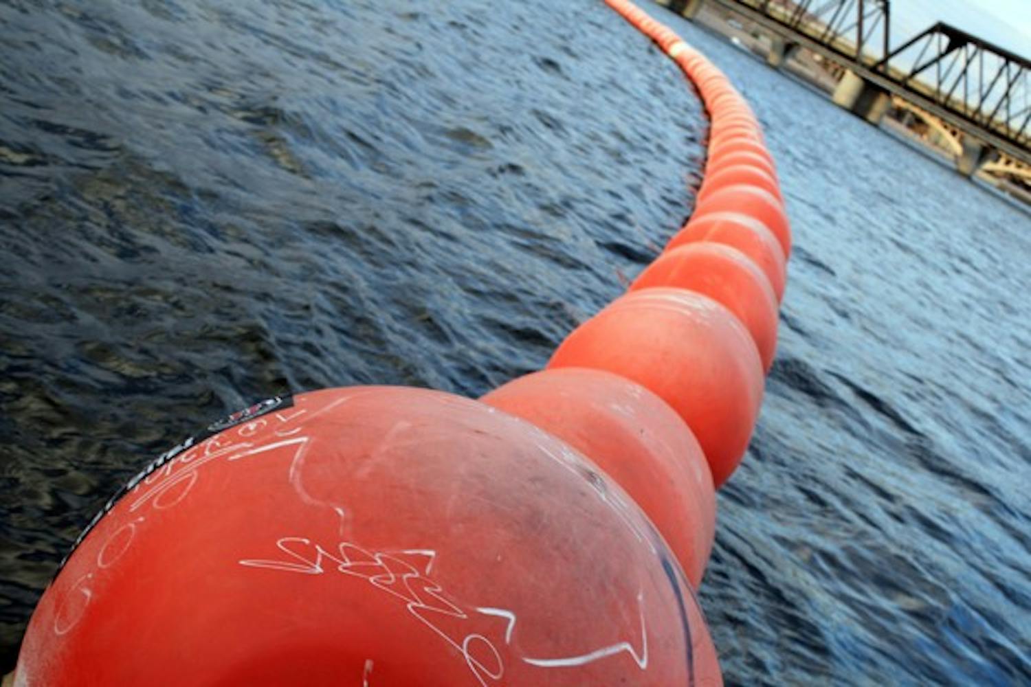 The bright orange buoys that keep Tempe Town Lake-goers safe bounce with the waves as the wind whips over the water at dusk. (Photo by Jessie Wardarski)