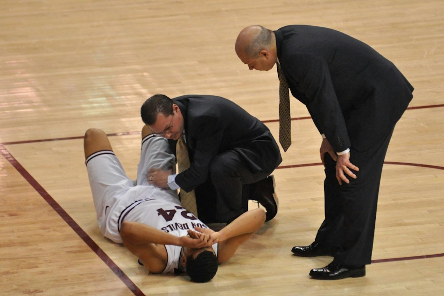 Trent Lockett's ankle is examined on the court by a trainer and coach Herb Sendek after he injured it with 10 minutes remaining in the game. Sendek told reporters during the postgame press conference that Lockett's x-ray results came back negative and that Lockett had badly sprained his ankle.  (Photo by Aaron Lavinsky)
