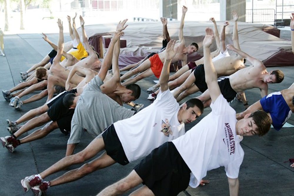 REACHING OUT: The men’s cross-country team engages in a side-plank stretch during a practice before the season. The Sun Devils travel to Minnesota for the Roy Griak Invitational on Saturday. (Photo by Beth Easterbrook)