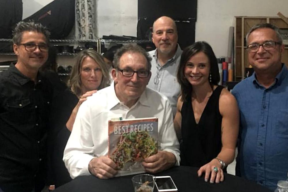 AZ Highways staff surround Paul Markow as he holds the book "Arizona's Best Recipes" in which he features Arizona Highways' favorite Arizona recipes.