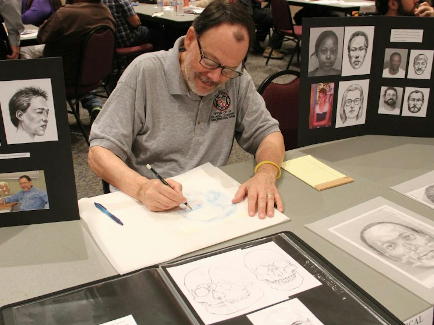 Forensic artist Stephen Missal draws sketches of missing persons to help the public visualize who they might be looking for at the inaugural Missing in Arizona day at ASU West campus on Oct. 24, 2015. 