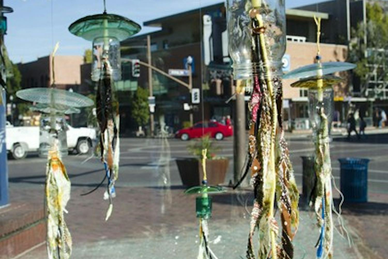 Art sculptures made of recycled materials, including USB cords, wires, glass, and yarn, are on display in the windows of the US Post Office on Mill Avenue as part of Tempe Green Revolution. (Photo by Ana Ramirez)