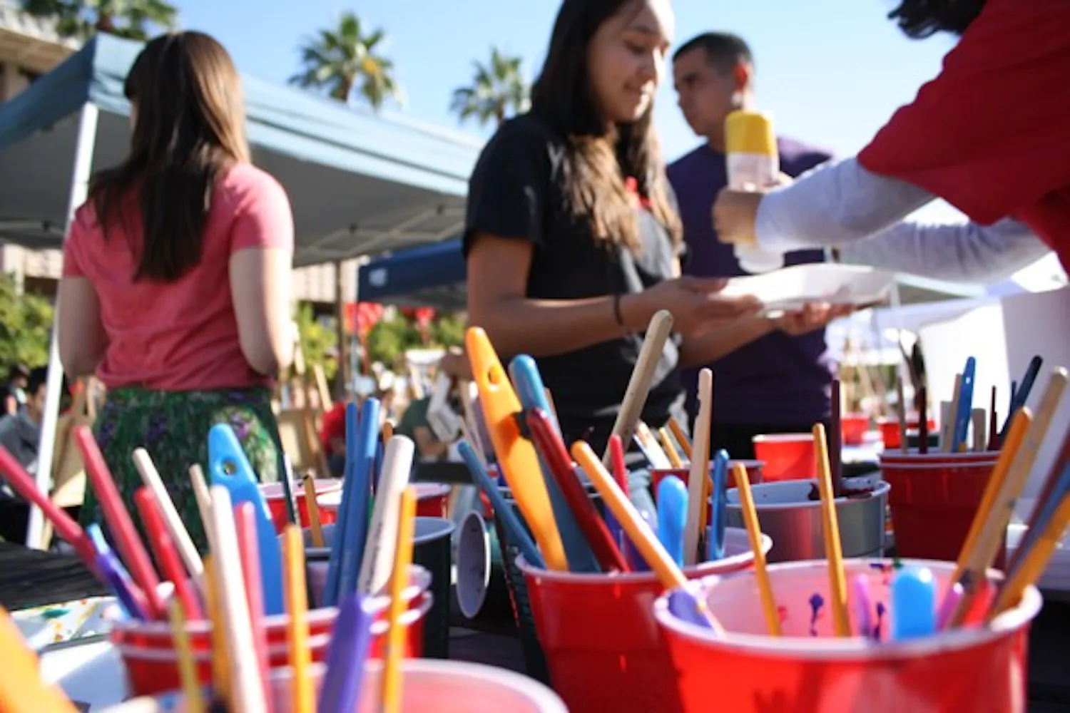 Students use paint brushes, trays and easels to translate their ideas of AIDS in the world onto a canvas during the Paint for Peace awareness event Wednesday afternoon on Hayden lawn. (Photo by Jessie Wardarski)