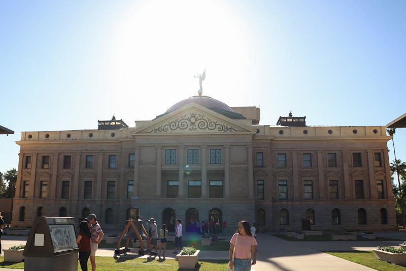 People walk past the Arizona State Capitol on Thursday, April 11, 2024 in Phoenix.