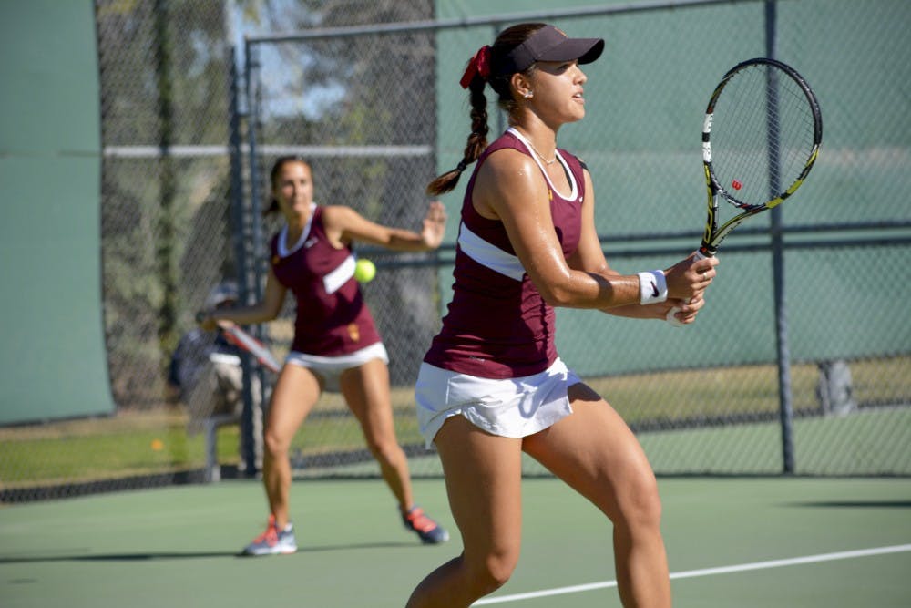 Vladhit: Junior Stephanie Vlad (left) returns the ball to UC Davis doubles partners, while her partner, junior Desirae Krawczyk, awaits the return on Saturday, Jan. 15, 2015, at Whiteman Tennis Center in Tempe. The match was abandoned due to a 4-3 ASU lead in doubles match. (Krista Tillman/ The State Press)