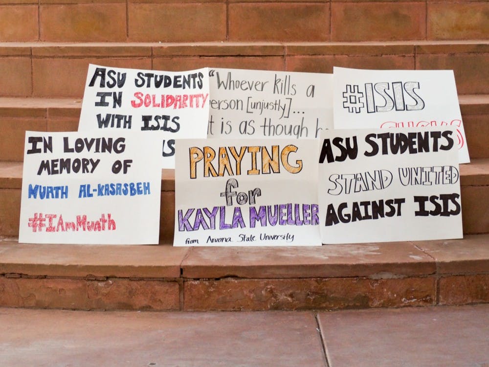ASU students made signs to show sympathy for victims of the Islamic State of Iraq and Syria.  The vigil was organized by student organizations to protest the actions of ISIS. (J. Bauer-Leffler/The State Press)
