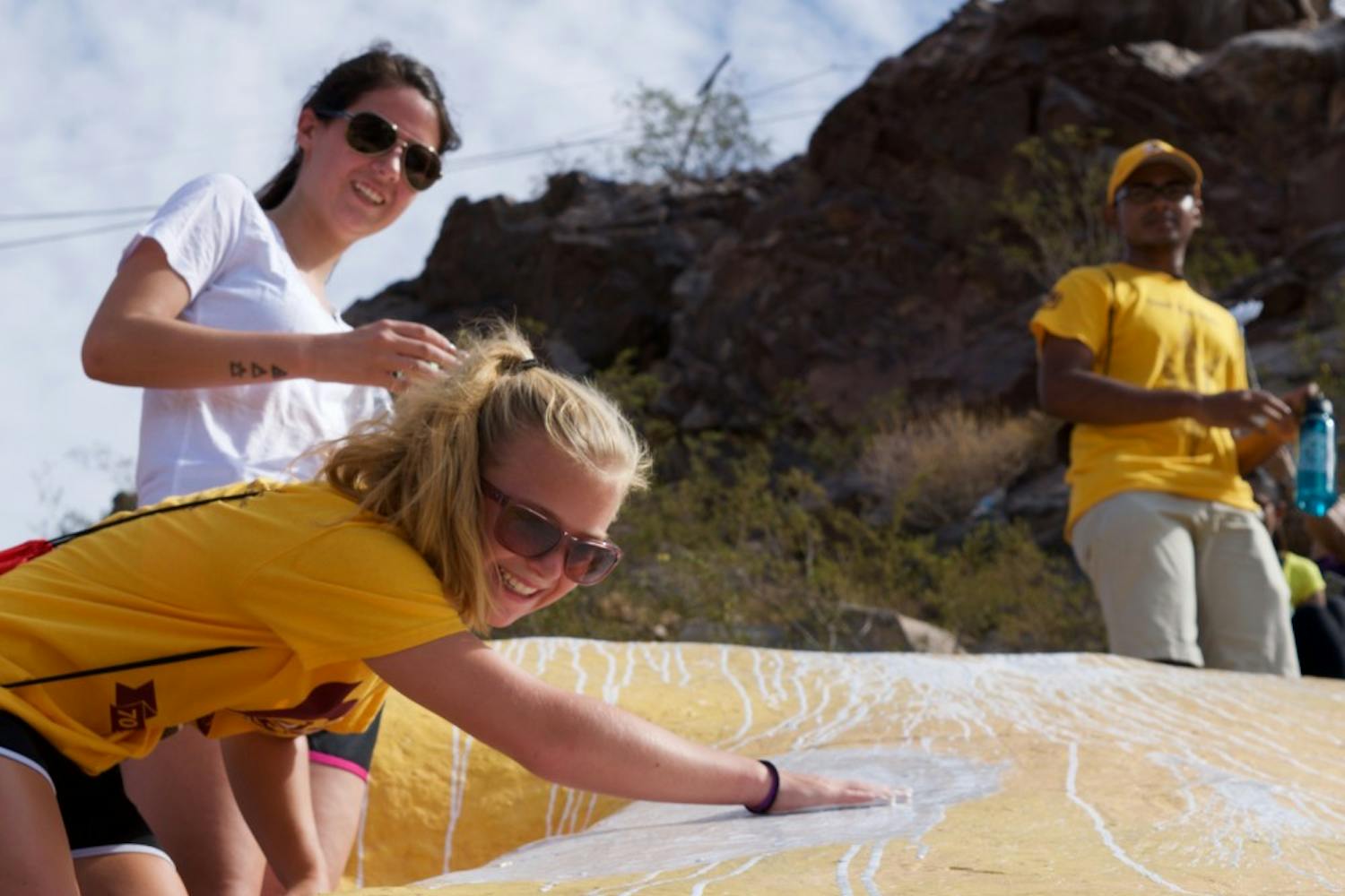 Freshman speech and hearing science major Amanda Mael and freshman art and education major Liz Wagstaff add their cups of paint to the A on Hayden Butte, also known as A Mountain, in Tempe, Arizona, on Aug. 20, 2016. Hundreds of students hike the mountain every fall to add a fresh coat of white paint to the A that sits on the hillside. 