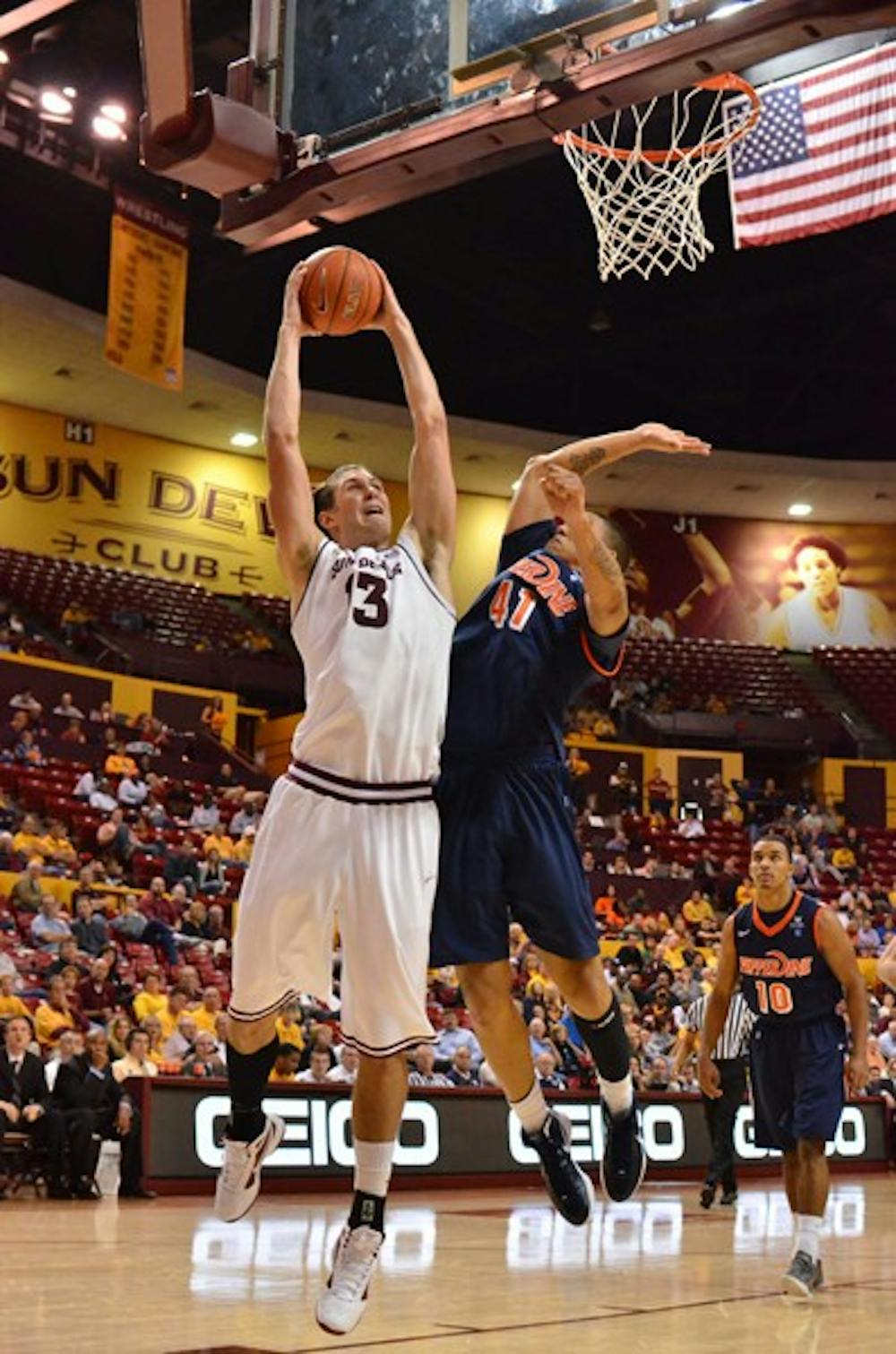 NOT ENOUGH: ASU sophomore center Jordan Bachynski tries to work past senior forward Taylor Darby during the Sun Devils’ 66-60 loss to the Waves on Tuesday. ASU coach Herb Sendek brought in Bachynski and freshman guard Max Heller to try to spark the Sun Devils in the second half, but the surge came up short. (Photo by Aaron Lavinsky)