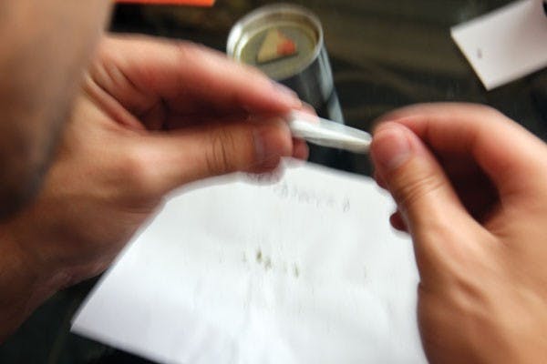 Mychael Zito, 23, finishes rolling his medication into a joint before smoking it. (Photo by Shawn Raymundo)