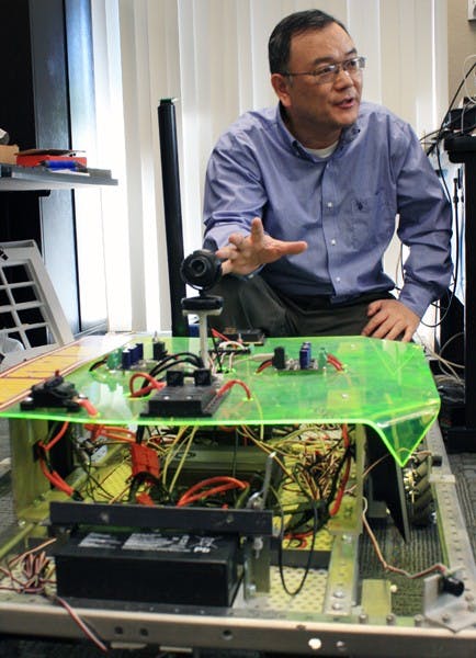 Lecturer Yinong Chen explains the construction and idea of a previously constructed robot similar to the one three ASU students will build in a competition in China this summer. (Photo by Jessie Wardarski)