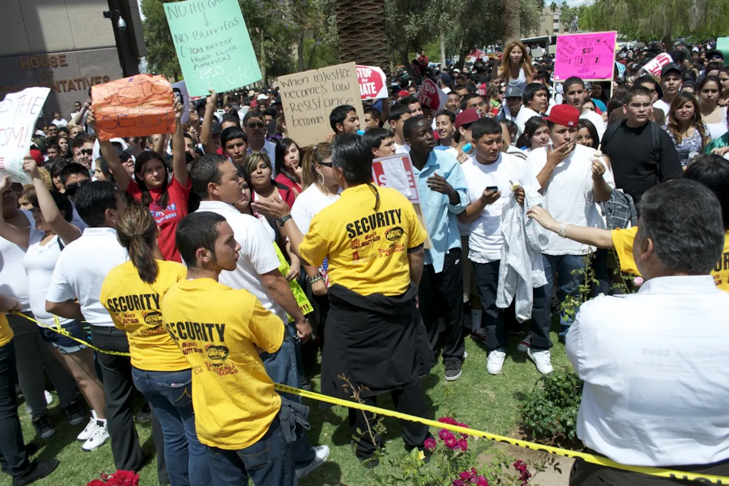 Volunteer security people work to keep protesters behind the caution tape on the Capitol lawn Friday afternoon. (MOLLY SMITH | THE STATE PRESS)