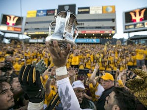 Sun Devil players hoist the Territorial Cup after winning a game against the Wildcats at Sun Devil Stadium in Tempe, Ariz., on Saturday, Nov. 21, 2015. The ASU Sun Devils took down the UA Wildcats, 52-36. 