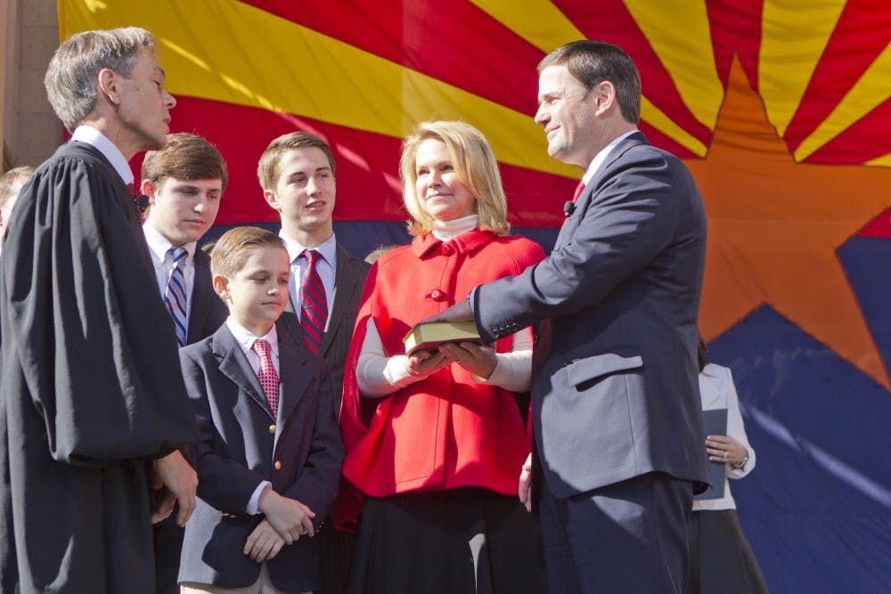 Doug Ducey taking his oath to office as Arizona's governor with his family beside him.  The inauguration took place at the State Capitol courtyard on January 5, 2015.  (Photo by Emily Johnson)